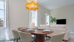 A dining area with a wooden table, four chairs, and a hanging light fixture. - Genteel Home San Anton 204 (Granada)
