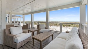 A covered outdoor seating area with wicker furniture and a view of the beach. - Saylor's Delight: Beachfront NEW BUILD, Sugar Sands Mexico Beach, Private Pool & (Mexico Beach)