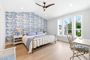 A bedroom with a bed, nightstands, a chair, a table, and a window with a view. - Gorgeous Union Pier Condo With Association Pool! Close To Beach and Downtown! (Union Pier)