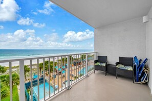 A balcony with a view of the beach and pool area. - The Summit 525 (Panama City Beach)