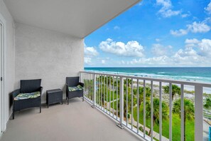 A balcony with wicker furniture, a white railing, and a view of the ocean. - The Summit 525 (Panama City Beach)
