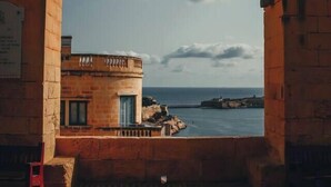 Un arco conduce a un edificio con vista sul mare.