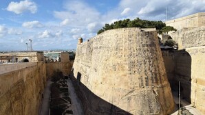 Un muro di pietra storico con un passaggio stretto.