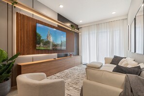 Una sala de estar moderna con un televisor de pantalla plana grande, un muro decorativo de madera, un sofá y una planta en maceta.