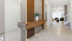 Ein modernes Interieur mit einem Holzbüro, einer Blumenvase und einer Treppe zu einer weiteren Ebene.