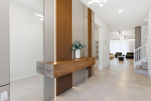 Ein modernes Interieur mit einem Holzbüro, einer Blumenvase und einer Treppe zu einer weiteren Ebene.