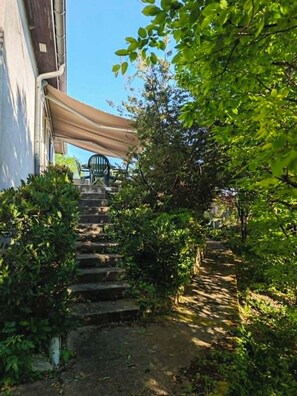 A staircase leading up to a building with a covered outdoor seating area. - Large house with garage, little corner of greenery, close to the center of Dijon (Talant)