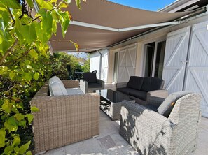 A covered outdoor seating area with wicker furniture and a large umbrella. - Large house with garage, little corner of greenery, close to the center of Dijon (Talant)