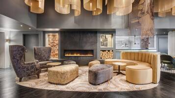 A modern lounge with a fireplace, seating, and pendant lighting.