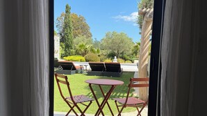 Una habitación con vistas a un jardín, una mesa y sillas.