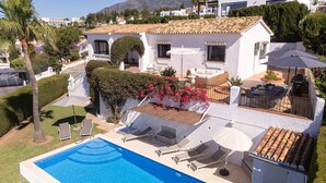 A white villa with a swimming pool, outdoor seating, and a view of the surrounding landscape. - Villa Sabine - Spectacular Sea View Villa in Capel (Benalmádena)
