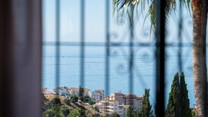 A coastal view with buildings, palm trees, and a clear sky. - Villa Sabine - Spectacular Sea View Villa in Capel (Benalmádena)