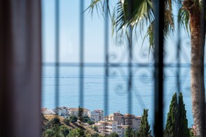 A coastal view with buildings, palm trees, and a clear sky. - Villa Sabine - Spectacular Sea View Villa in Capel (Benalmádena)