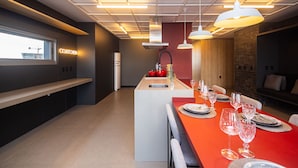 Una cocina moderna con una isla integrada, iluminación colgante y vistas a la ciudad.