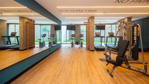 Un gimnasio con cintas de correr, bicicletas estáticas y máquinas de pesas.