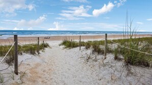 A sandy beach path leading to the ocean, with a rope barrier and wooden posts. - Grand Floridian|Heated Pool|Walk to Beach|Sleeps 12 (St. Augustine)