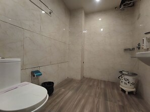 Une salle de bain avec des toilettes, une douche et un lavabo.