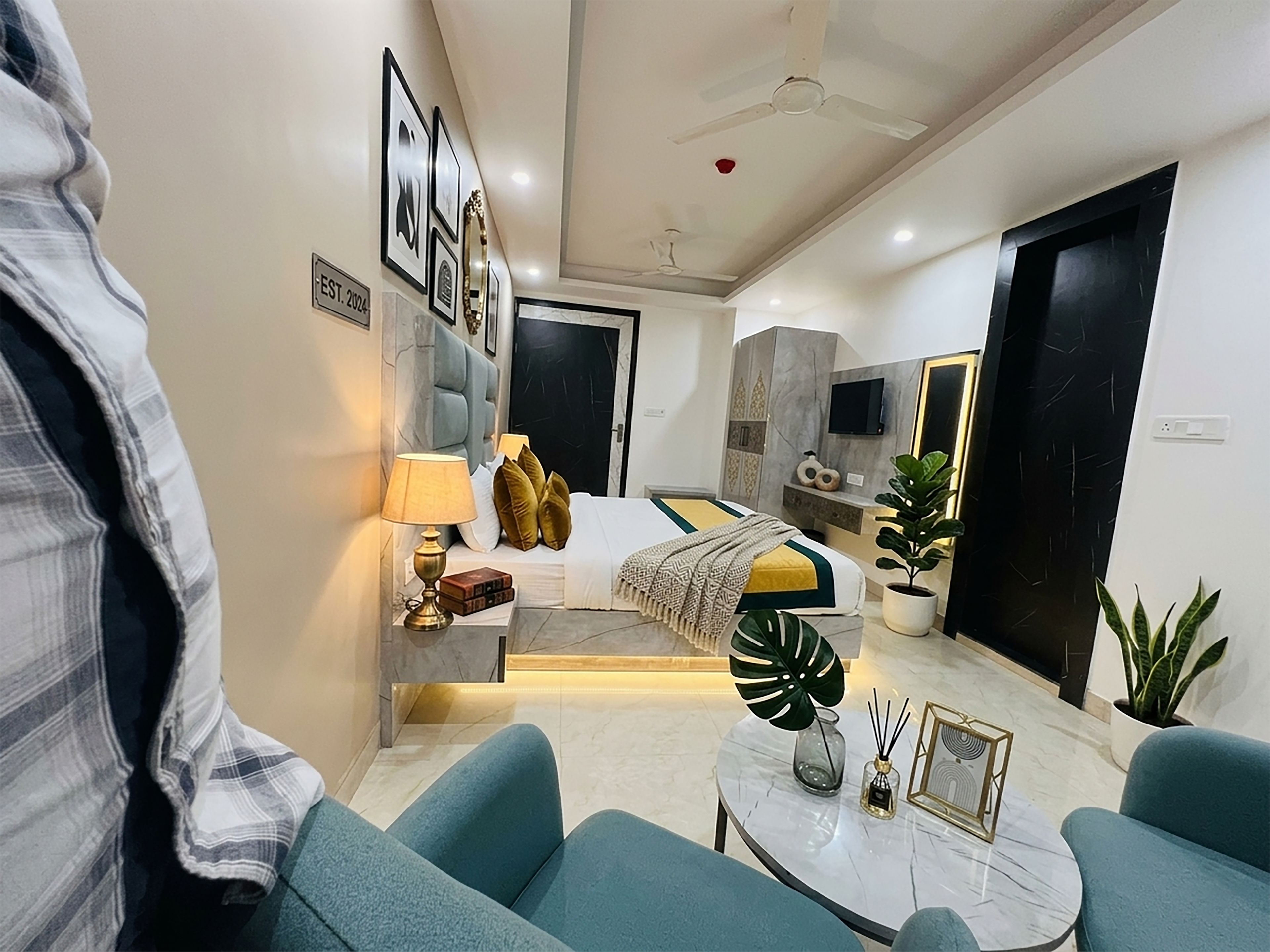 Ein modernes Hotelzimmer mit Bett, Sitzecke und Fernseher.