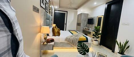 Ein modernes Hotelzimmer mit Bett, Sitzecke und Fernseher.