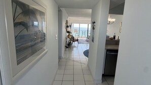 Ein Flur mit Blick auf einen Balkon, einen Essbereich und eine Küche.
