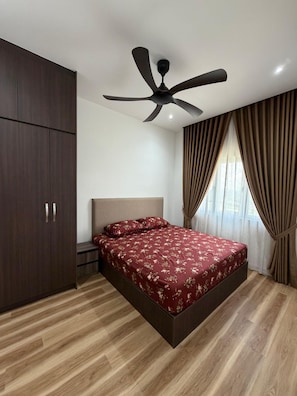 Un dormitorio con cama, ventilador de techo, armario y cortinas.