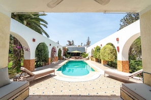A swimming pool with lounge chairs, surrounded by arches and greenery. - Palm Paradise | 3BR Villa · Pool · La Soukra (La Soukra)