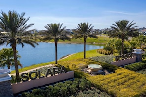 Das Resort Solara mit Blick auf einen See, Palmen und einer gepflegten Rasenfläche.
