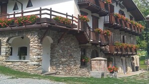 A traditional stone building with multiple balconies adorned with flower boxes.