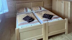 Un letto a castello in legno con una testiera, un piccolo armadietto e una lampada a sospensione.