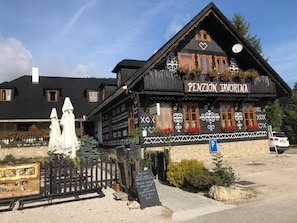 Un edificio tradicional de madera con un letrero que dice 'PENZION JAVORINA'.