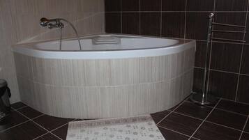 Une salle de bain avec une baignoire sur pieds, un porte-serviettes et un tapis à motifs sur le sol.