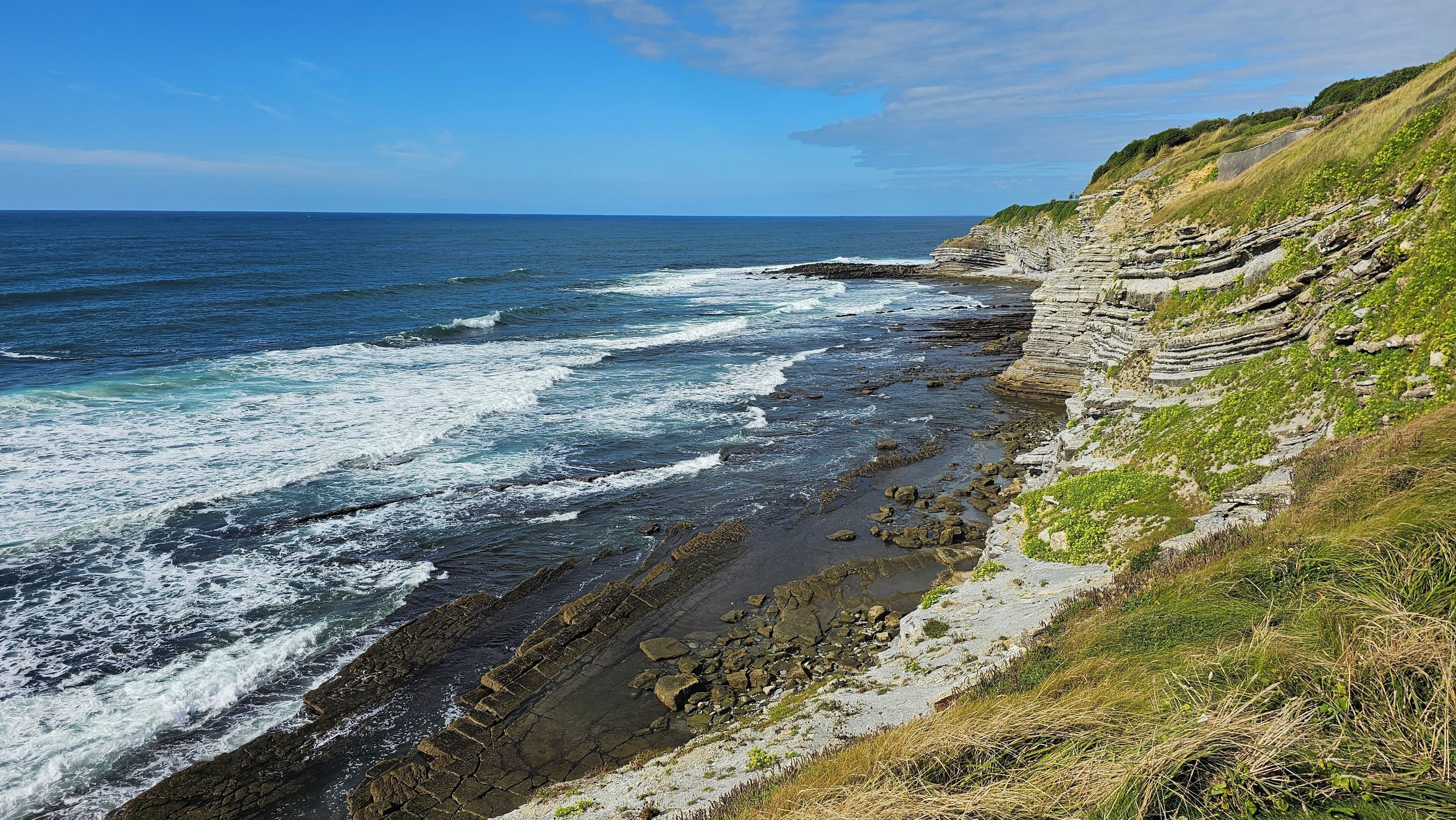 Un paysage côtier avec des falaises rocheuses et des vagues.
