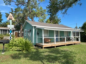 A small, single-story house with a porch, a mailbox, and a wooden deck. - Old Florida Fish Camp Cedar Key (Cedar Key)