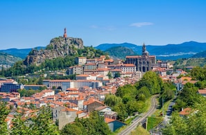 Une ville qui se distingue par son église imposante, une statue située sur une colline et une voie ferrée.
