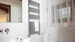 A bathroom with a sink, mirror, towel rack, and a window with sheer curtains. - Lilum B&B Villa Patrizia - Mamo Florence (Itri)