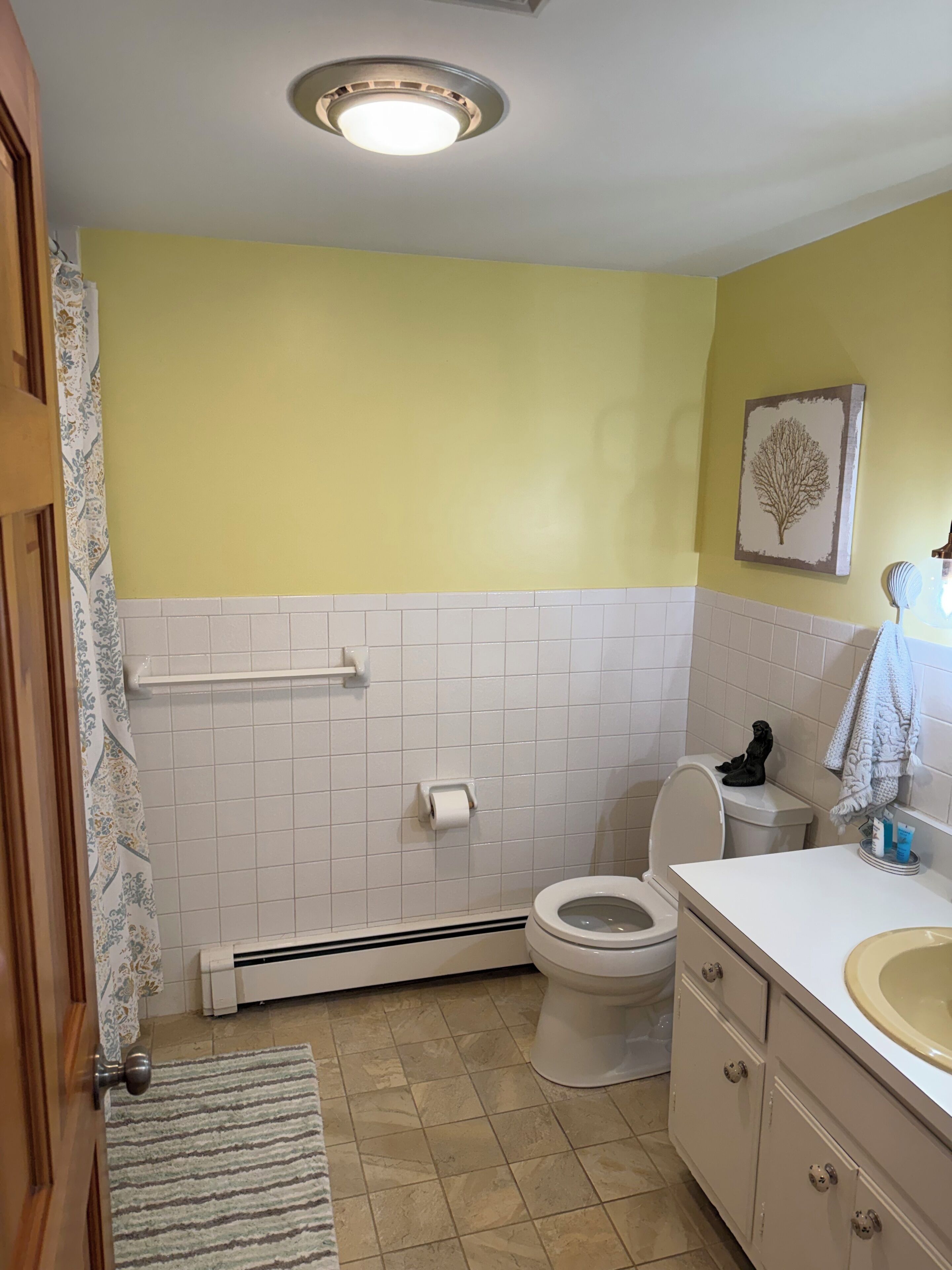 A bathroom with a toilet, sink, and a towel rack.