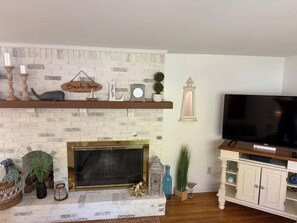 Ein Wohnzimmer mit Kamin, Fernseher und Bücherregal.
