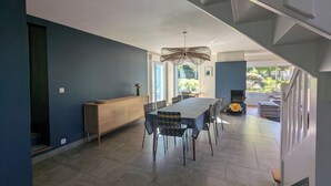 Un'elegante zona pranzo con tavolo e sedie, una panca in legno e una lampada a sospensione.