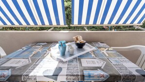 A table with a tray, cups, and a bowl of bread and fruit. - Casa AzzurroLido (Alghero)