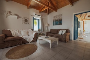 A cozy living room with two sofas, a coffee table, and a woven rug. - Apartment with Balcony - Sea Mansion Lefkada (Lefkada)