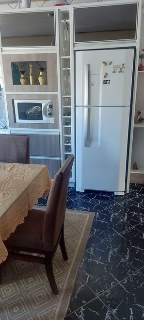 Eine KĂŒche mit KĂŒhlschrank, Mikrowelle und Dekorationselementen.