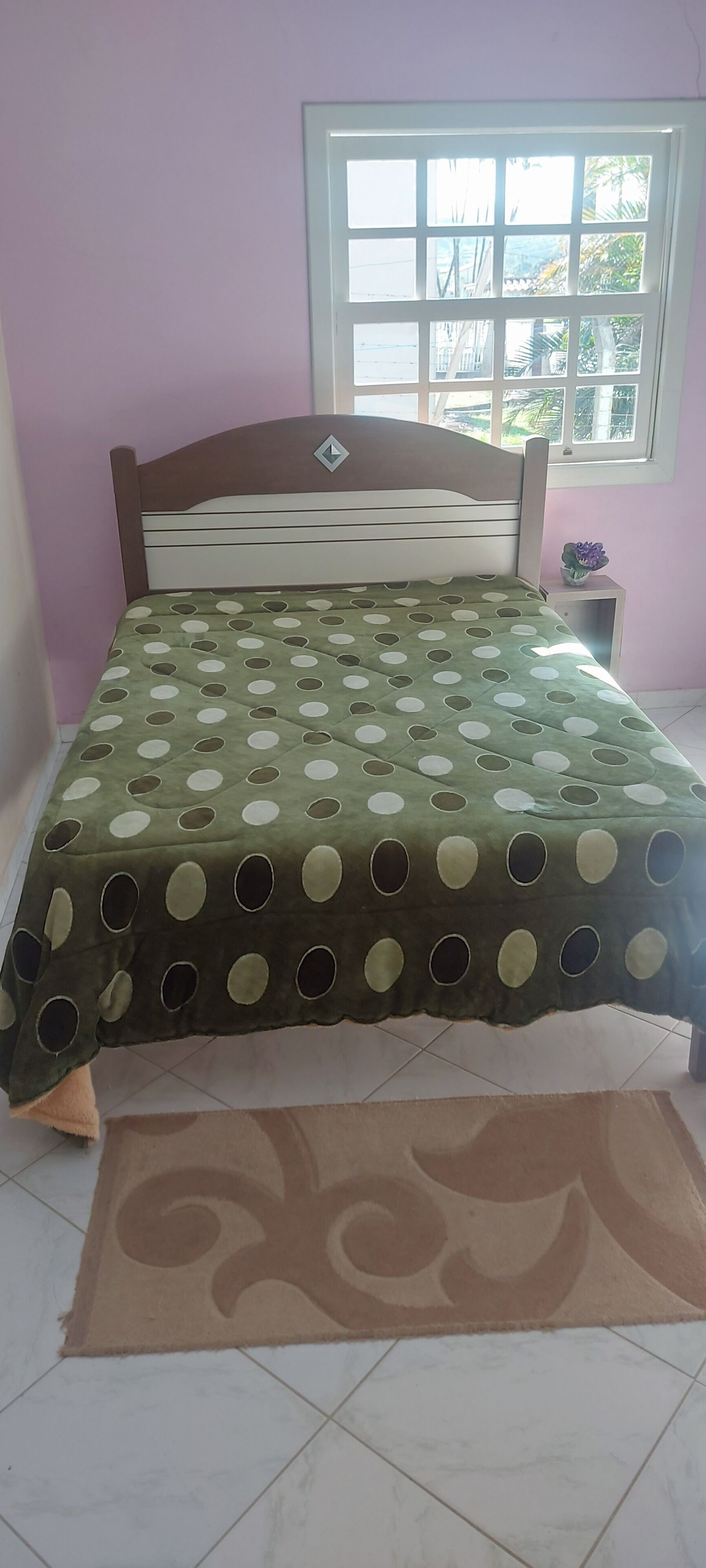 Une chambre à coucher avec un lit, une fenêtre et une table de chevet.