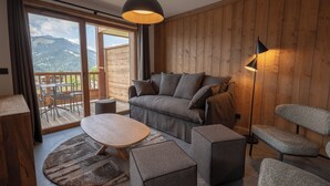 A modern living room with a wooden floor, a sofa, a coffee table, and a lamp.