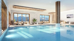 A modern indoor pool with clear views of mountains, large windows, and lounge chairs.