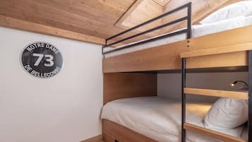 A bunk bed room with a wooden ceiling and a circular sign on the wall.