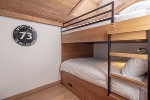 A bunk bed room with a wooden ceiling and a circular sign on the wall. - TERRESENS - Les Balcons de Juliette (Notre-Dame-de-Bellecombe)