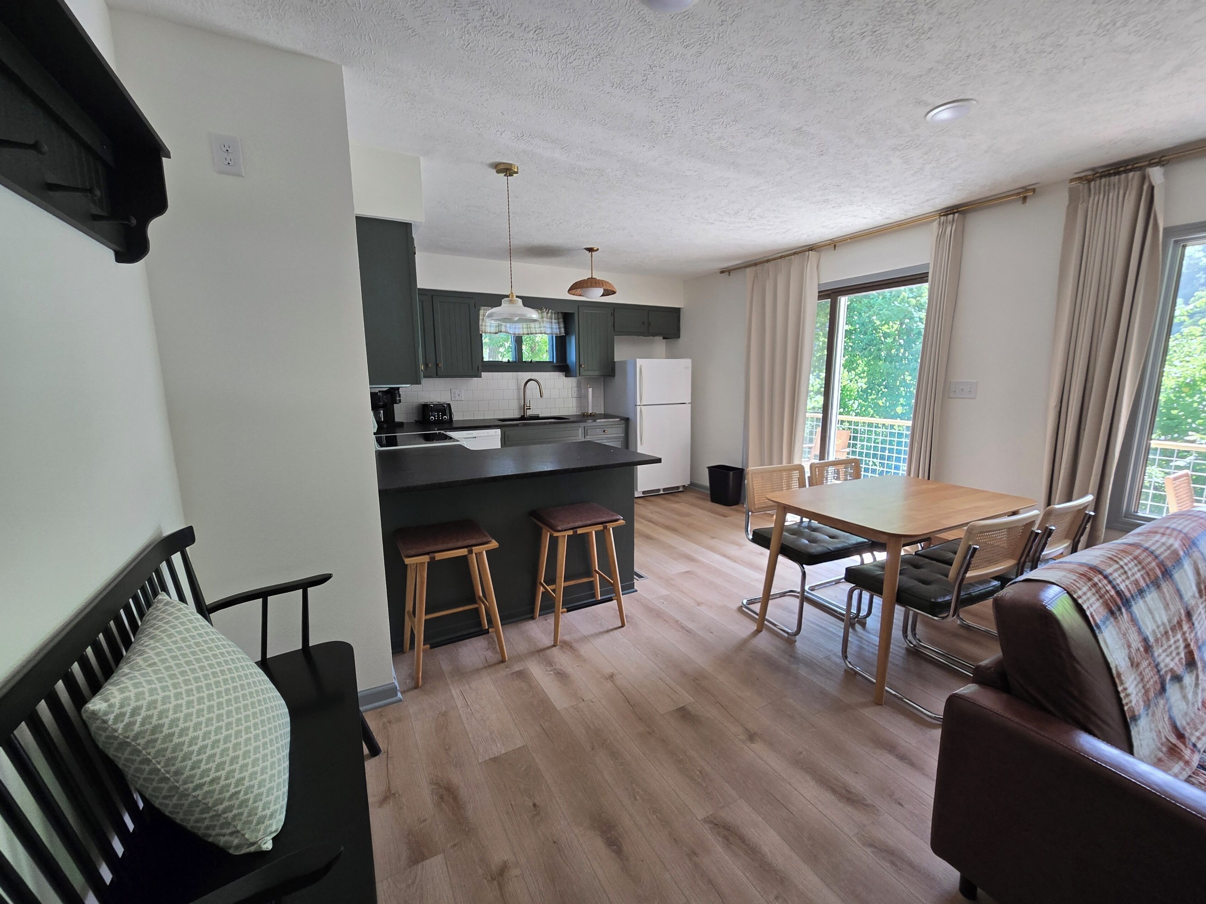 Un espacio habitable compacto con kitchenette, comedor y sofá.