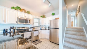 A modern kitchen with white cabinets, stainless steel appliances, and a granite countertop. - 2 Blocks to Beach & Boardwalk – 3BR/2BA in Gold Coast, OCNJ (Ocean City)