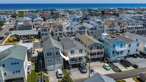 A residential area with houses, a clear sky, and a view of the ocean. - 2 Blocks to Beach & Boardwalk – 3BR/2BA in Gold Coast, OCNJ (Ocean City)