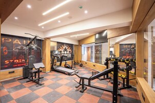 A gym with exercise equipment, a mirrored wall, and motivational posters.
